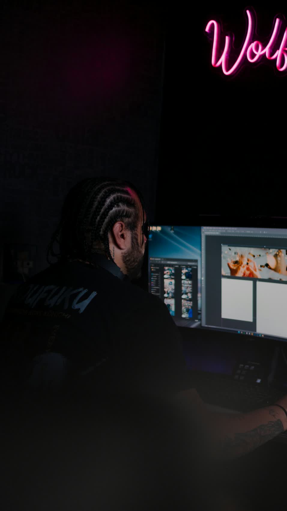 Creative professional working at computer with neon studio lighting - content creation